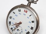 une montre de poche en argent avec des chiffres romains