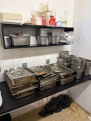de nombreux plateaux de nourriture posés sur une étagère dans une cuisine