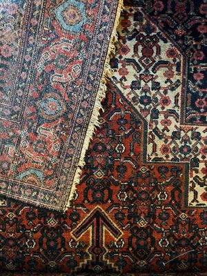 Plusieurs tapis orientaux sont disposés sur le sol dans une pièce