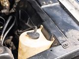 a car engine with the hood open and the oil can be filled with water