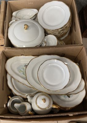 plusieurs assiettes et bols dans une boîte posée sur le sol