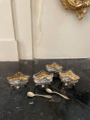 cinq bols et cuillères en argent posés sur une table