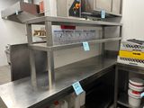 une cuisine avec de nombreux plans de travail en inox