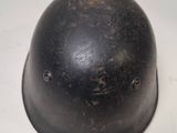 an old black helmet sitting on top of a white table