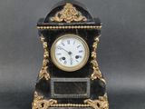 a black and gold clock with roman numerals on it