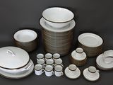 a lot of white and brown dishes and cups and saucers
