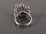a close up of a ring with a red stone in it