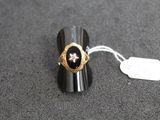 une bague noire et dorée ornée d'une étoile