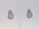 une paire de boucles d'oreilles en or blanc et diamants exposée sur un présentoir