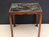 une vieille table en bois avec un plateau en marbre, posée sur un plan de travail blanc