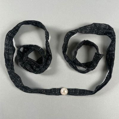 CHANEL. Ceinture en tissu tweed noir et argenté, un bouton p…