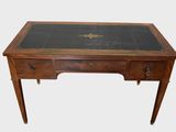un bureau ancien avec un plateau en verre et des ferrures en laiton