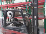 a red fork truck parked in a warehouse next to a stack of pallets