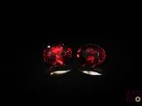 une paire de boucles d'oreilles à clous en verre rouge sur fond noir