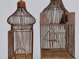 pair of antique bird cages with a bird in a cage and a bird in a cage