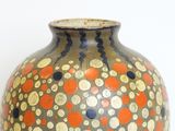 a vase that has a lot of dots on it