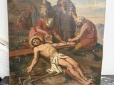 tableau représentant Jésus cloué sur la croix posée sur une table