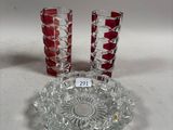 three glass vases and a glass plate on a white surface