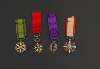 four medals are displayed on a black surface in a row