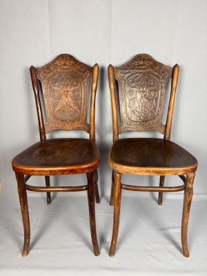 paire de chaises anciennes en bois avec des assises rembourrées de cuir