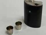 a flask and two cups on a white surface