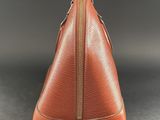 a brown purse with a zipper on top of it