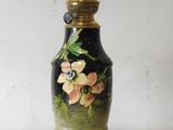 a black and gold vase with flowers painted on it