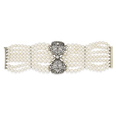 un gros plan sur un bracelet blanc orné de perles et de diamants