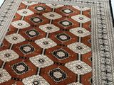 an orange and black rug with a diamond design on it