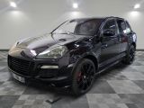 La Porsche Cayenne noire est garée sur un sol à damier