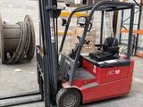 a red fork truck parked in a warehouse next to a stack of pallets