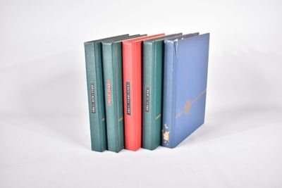 trois livres sont empilés sur une surface blanche