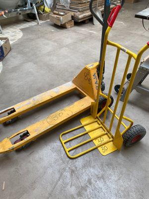 a yellow hand truck with a fork on it in a warehouse