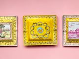 trois assiettes jaunes et dorées ornées de motifs sur fond rose