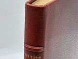 an old book sitting on top of a white table next to a white wall