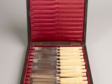 six knives in a black case with red lining