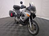 une moto qui est garée dans une pièce dont le sol est en damier