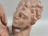two statues of a woman and a man on a white surface