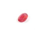 une pierre ovale rouge sur une surface blanche