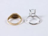 two gold and silver rings sitting side by side on a white surface