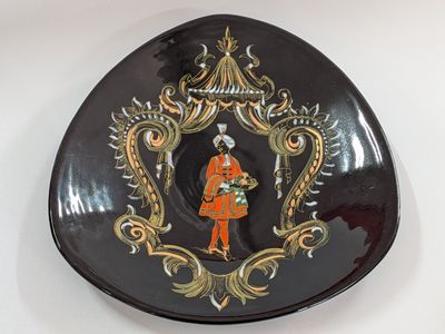 a black plate with a picture of a woman in a red coat