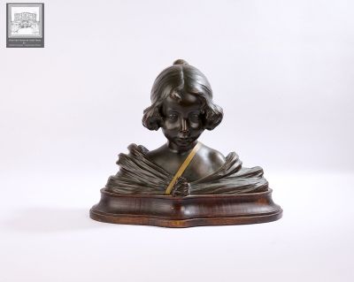 statue d'une femme en train de lire un livre, posée sur un socle en bois