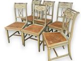 quatre chaises avec des assises en osier et des dossiers en rotin sur fond blanc