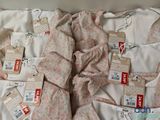 two sets of pajamas with tags on them sitting on a bed