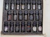 many bottles of essential oils in a box on a table