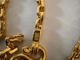 a picture of a gold necklace with a snake on it