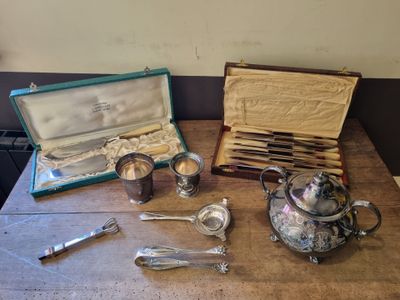 a wooden table with silverware on it and a silver teapot