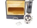 une montre posée à côté d'un coffret à montres