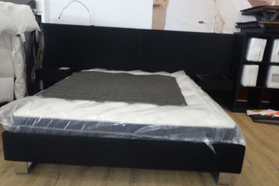 un lit sur lequel est posé un matelas dans une pièce