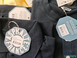 two shirts with tags on them on a table
